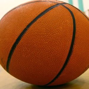 A close up of an orange basketball on the floor