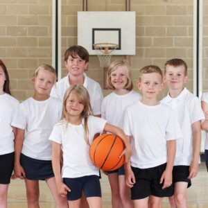 A group of children in white shirts holding a basketball.