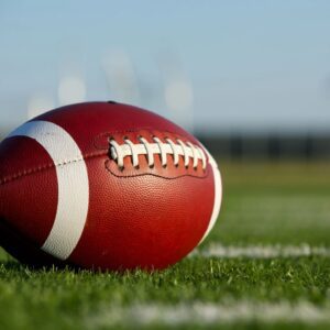 A football sitting on top of a green field.