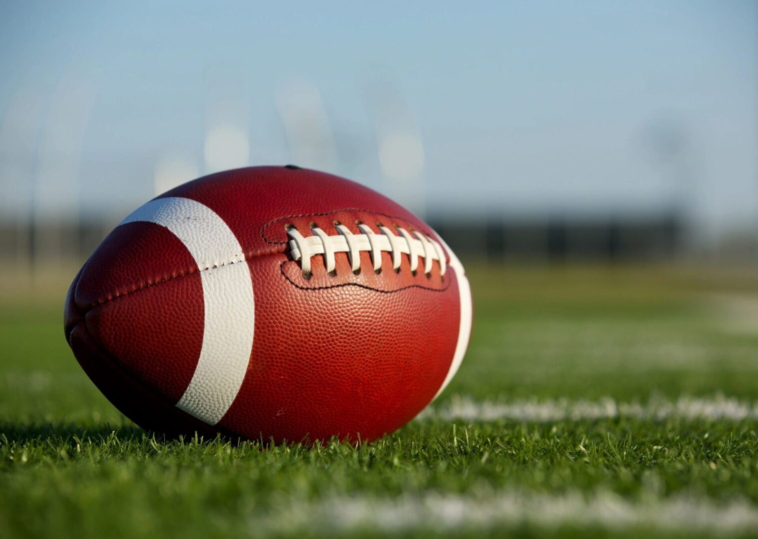 A football sitting on top of a green field.