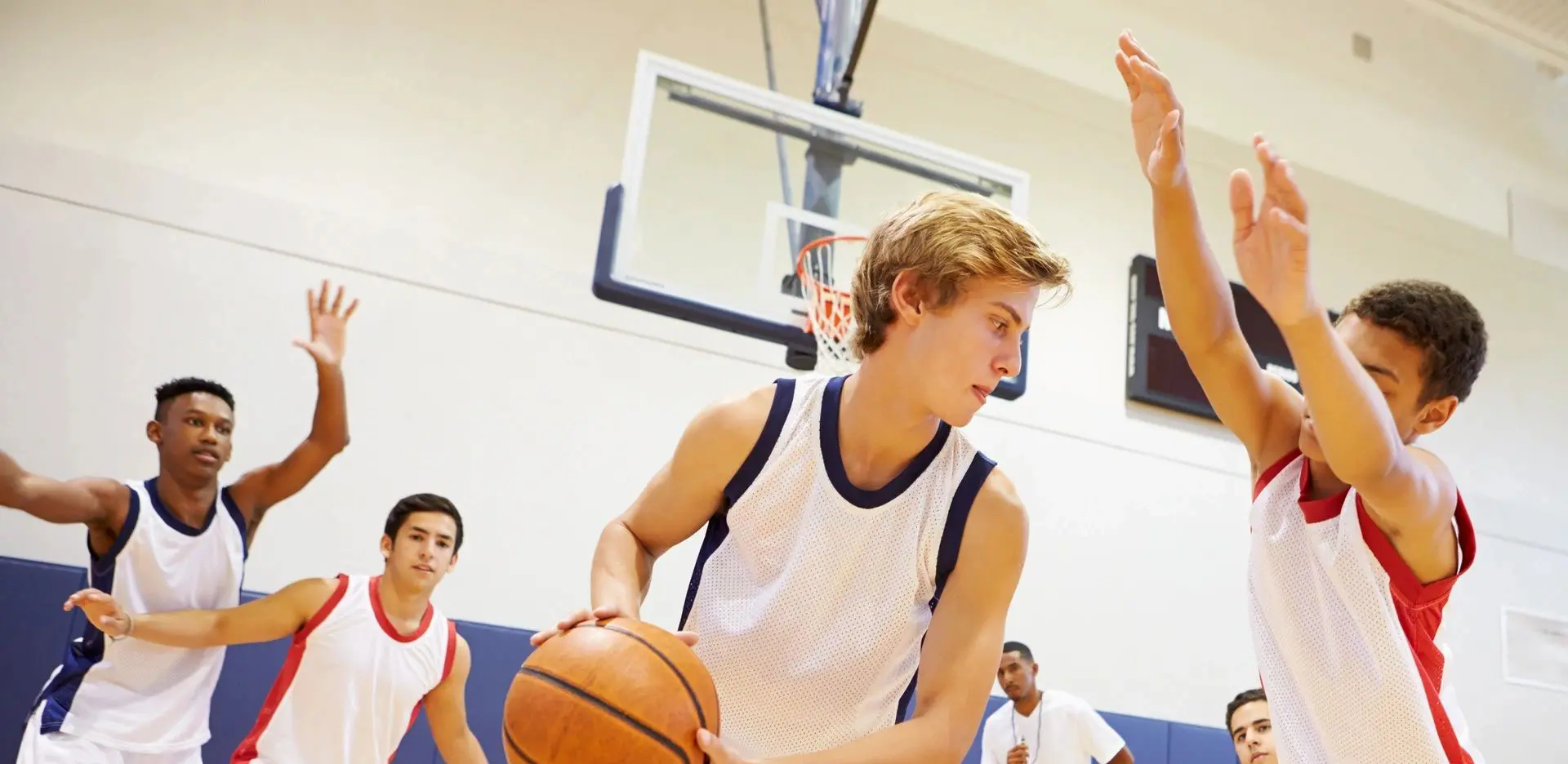 A boy holding onto the basketball while playing basketball.