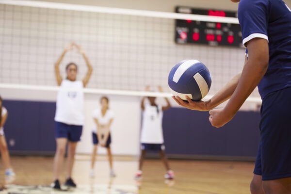 A group of people playing volleyball on a court.