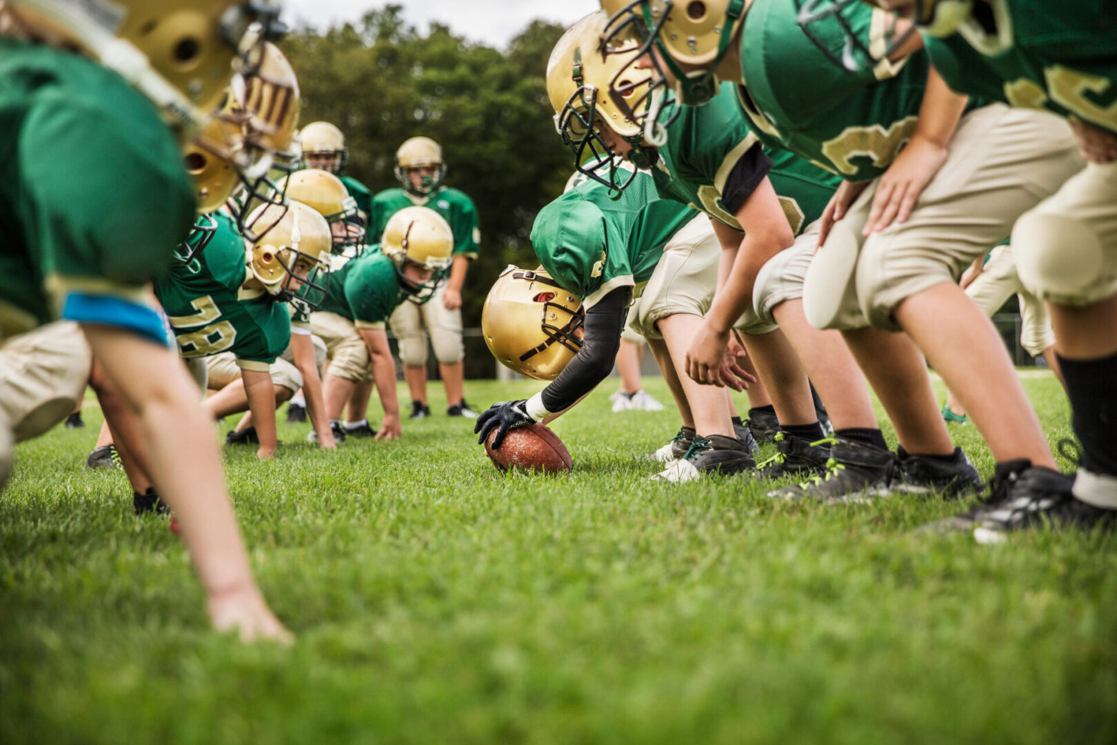 A group of football players in green and gold uniforms.