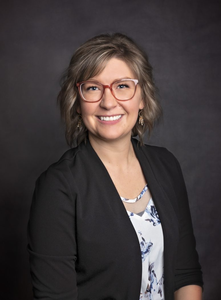 A woman with glasses and a black jacket